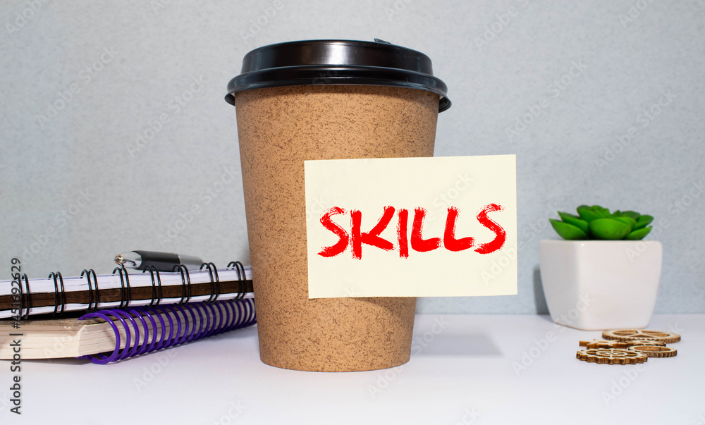 Aufkleber notes with the word skills on a blue background. knowledge and skill. self improvement.
