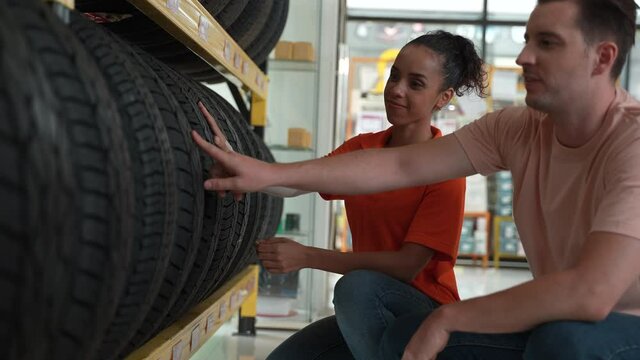 Auto Service Expertise: Technician Advising Customers on Premium Tires and Wheels at a Vehicle Repair Center Focused on Engine Performance