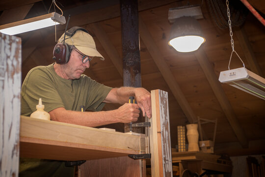 Furniture Maker Glues And Clamps New Cabinet In His Woodshop
