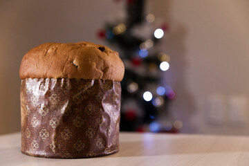 Panettone with blurry Christmas lights blinking in the background. Panettone concept. Christmas concept.
