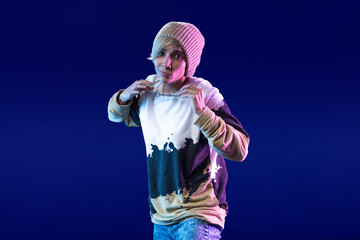 Fototapeta premium Latin woman dancing choreography in studio with casual clothes and blue background with purple