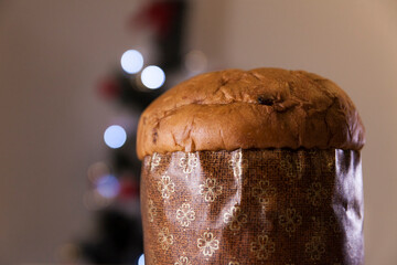 Panettone with blurry Christmas lights blinking in the background. Panettone concept. Christmas concept.
