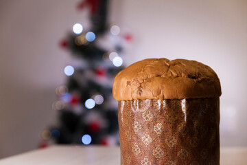 Panettone with blurry Christmas lights blinking in the background. Panettone concept. Christmas concept.
