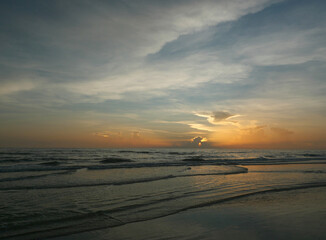 Fototapeta na wymiar Calm evening tides and big sky on coast