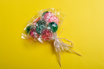 bouquet of lollipops on a yellow background.