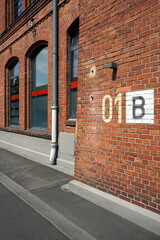 Kennzeichnung des Gebäudekomplex einer alten Fabrik aus braunem Backstein mit sanierter Fassade in...