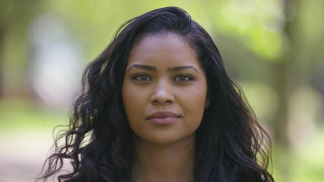 Portrait of young black female looking to camera with a blank expression