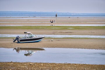 Maple Beach in Point Roberts USA. A boat beached on the sand at Boundary Bay at low tide in Point...