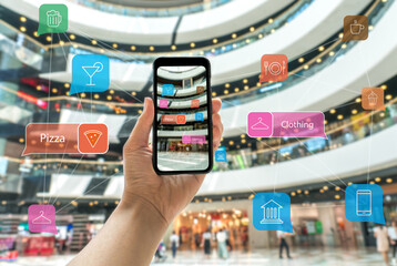 Augmented reality marketing in the shopping mall. Hand holding smart phone use AR application to...