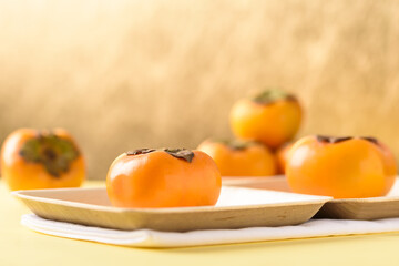 Persimmon fruit on golden background, tropical fruit mostly in Southeast Asia, refreshing and healthy eating sweet taste