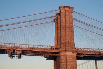 One of the towers of the famous old and historic Brooklyn Bridge spanning the East River from Manhattan into Brooklyn as seen at sunset