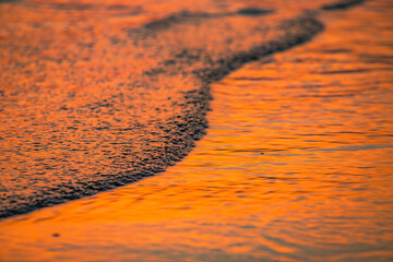 The texture of finely ribbed waves in the sunset light