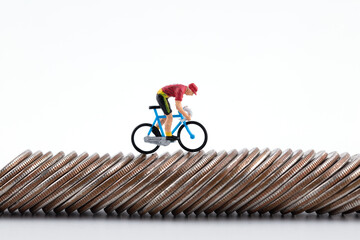 A doll on a bicycle on a row of coins