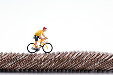 A doll on a bicycle on a row of coins