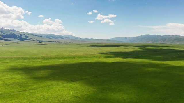 Vast grasslands and mountains in a fine day.
