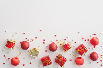 Flat lay of Christmas composition, gift box, ornament on white background copy space minimal style. Christmas ornament for decoration in xmas new year winter festival.