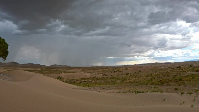 Panning view of rain storm moving in over the Little Sahara sand dunes during summer monsoon in Utah.