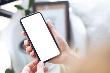 cell phone blank white screen mockup.woman hand holding texting using mobile on desk at office.background empty space for advertise.work people contact marketing business,technology - obrazy, fototapety, plakaty
