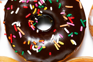 Close up of a chocolate frosted donut with rainbow sprinkles