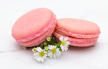 Pink macaroons on white marble background.