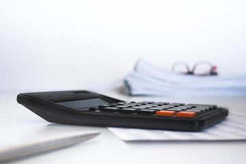 Stack of documents , calculator, pen placed on a business desk in a business office. Copy space