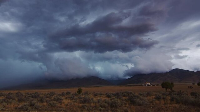Panning view of severe thunderstorm moving through Utah as lightning flashes in the clouds.