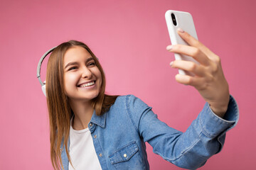 Photo of beautiful happy smiling young blonde woman wearing blue jean shirt and white t-shirt...