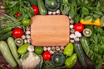Concept of healthy eating, food background with a border of fresh vegetables. Various vegetables wooden background, top view, flat layout. Frame of vegetables with space for text. Fresh vegetables