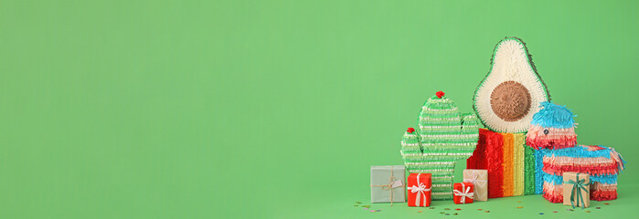 Different pinatas and gifts on color background with space for text