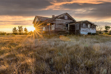 Abandoned home in a farmyard at sunset near Rush Lake, Saskatchewan