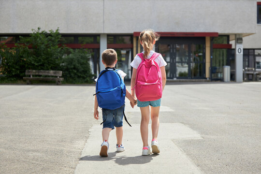 Back to school. Boy and girl go to school with backpacks. The beginning of the school year, children go to lessons
