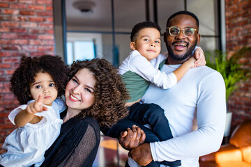 afro american mixed-raced family looking at camera in cozy summer day light in living room