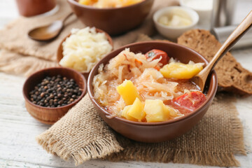 Bowl with tasty sauerkraut soup on table