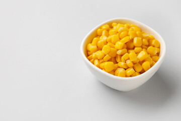 Bowl of corn kernels on white background