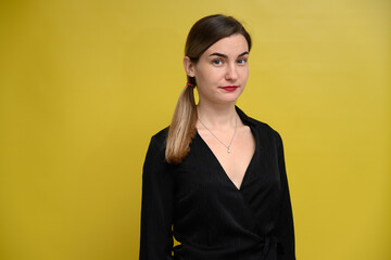 Business concept. Woman manager poses right in front of the camera, standing seriously on a yellow background. - 451723652