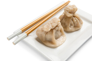 Plate with tasty dumplings and chopsticks on white background, closeup