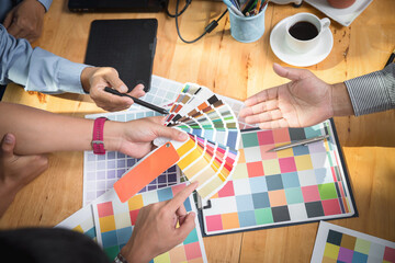 Interior designer chooses a color chart for home design. Graphic designers working on color chart at modern office.