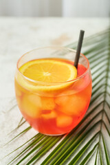 Glass of Aperol spritz cocktail on light background