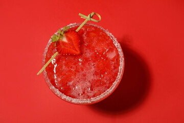Glass of tasty strawberry margarita on color background