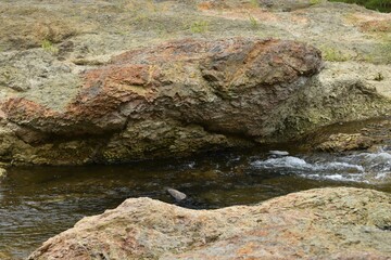 Naklejka na ściany i meble The small stream water flowing among the massive rocks in Sapporo Japan