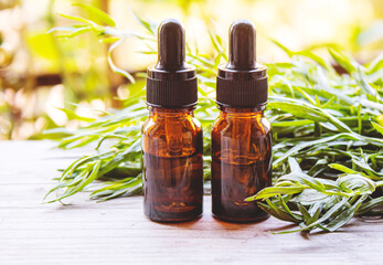 Essential oil of tarragon in a bottle. Selective focus.