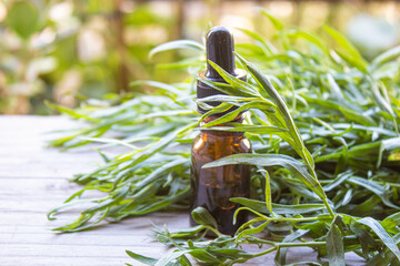 Essential oil of tarragon in a bottle. Selective focus.