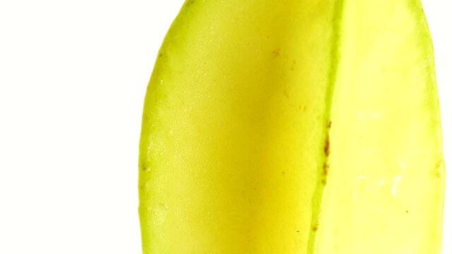 4K Organic star fruit carambola or star apple ( starfruit ) close-up rotates on a white background