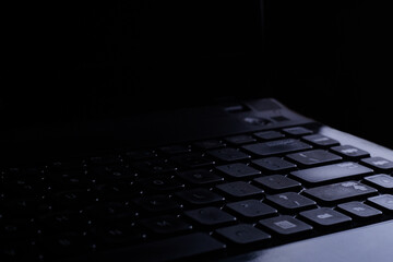 Looks close. Laptop on a black background and little lighting. Simple concept.