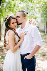 Fototapeta premium beautiful bride and groom pose coolly in the park