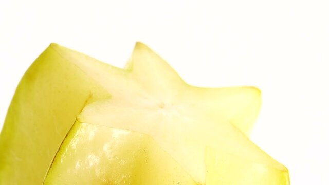 4K Organic star fruit carambola or star apple ( starfruit ) close-up rotates on a white background