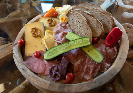 Delicious sausage and cheese plate perfectly garnished and cooked on a wooden board