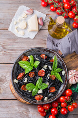 Black spaghetti pasta with tomatoes, cheese and basil