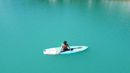 Fototapeta premium The girl bathes on a glanders. Warm summer day. Turquoise water. Aerial photography
