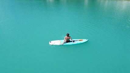 The girl bathes on a glanders. Warm summer day. Turquoise water. Aerial photography